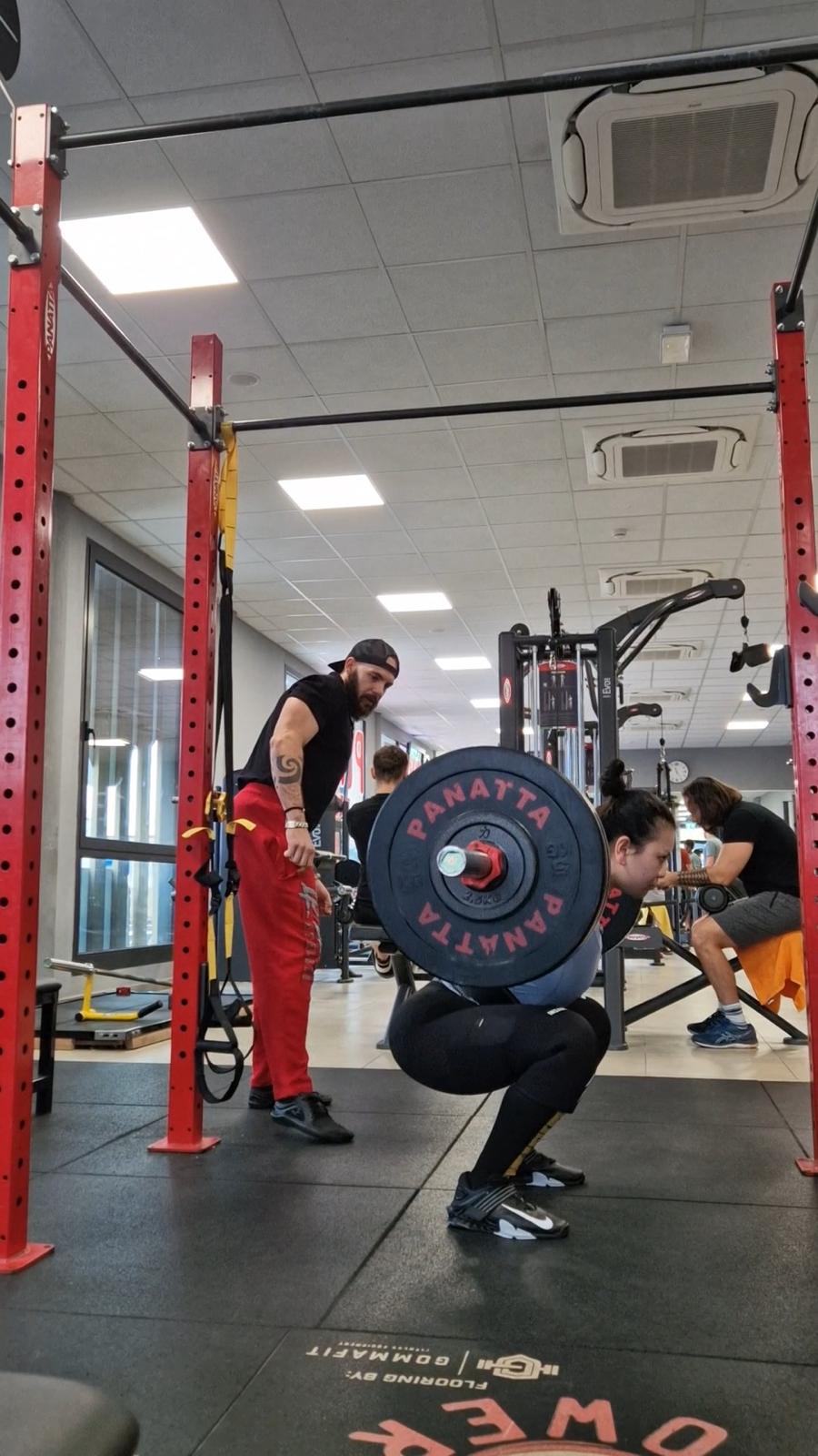 Christian osserva un'atleta durante uno squat con bilanciere